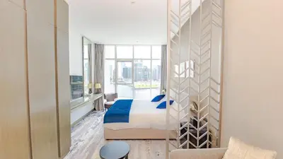 a hotel room with a bed and a large window at Conveniently Located Apartment With Waterfront View in Dubai