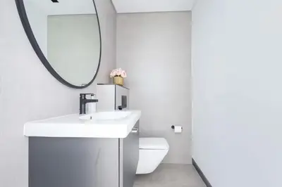 a bathroom with a white sink and a mirror at Luxury Apartment with Burj Khalifa View, Balcony Netflix WeHome Premium in Dubai