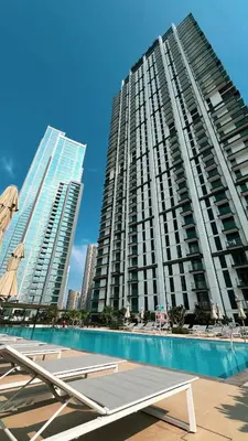 a large apartment building with a pool in front of it at Luxury 4BR Burj Khalifa View Dubai Mall in Dubai