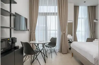 a hotel room with a bed and a table and chairs at Studio Revved Up in 15 Northside with Pool and Gym in Dubai