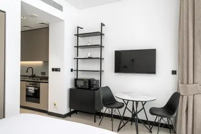 a kitchen with a table and chairs and a tv at Studio Revved Up in 15 Northside with Pool and Gym in Dubai