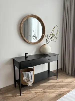 a black console table with a mirror on a wall at Oakley Square Oasis in JVC in Dubai