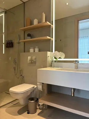 a bathroom with a sink and a toilet and a mirror at Oakley Square Oasis in JVC in Dubai