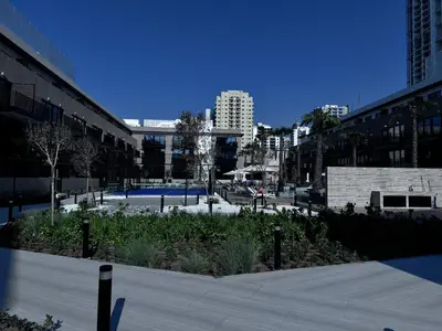 a park in a city with buildings and plants at Oakley Square Oasis in JVC in Dubai