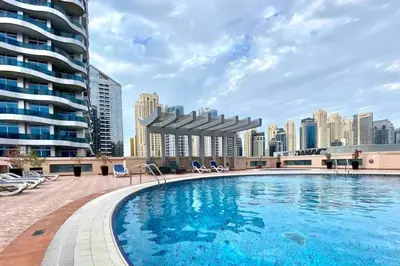 a swimming pool with a city skyline in the background at Cozy Studio at Marina near Beach and Metro in Marina Z817 in Dubai