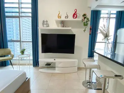 a living room with a flat screen tv on a wall at Cozy Studio at Marina near Beach and Metro in Marina Z817 in Dubai