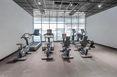 a gym with a bunch of cardio equipment in a room at Loci Residences - Vibrant Studio in JVC in Dubai