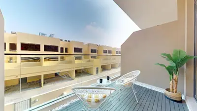 a balcony with a table and chairs and a building at Loci Residences - Vibrant Studio in JVC in Dubai