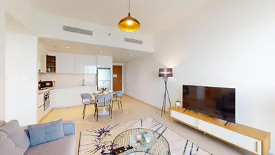 a living room with a couch and a table and a kitchen at Vacationer l High Rise 1 Bedroom l Close to Dubai Mall l Pool Access with Burj Khalifa Views in Dubai
