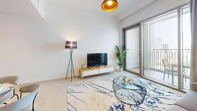 a living room with a glass table and a television at Vacationer l High Rise 1 Bedroom l Close to Dubai Mall l Pool Access with Burj Khalifa Views in Dubai