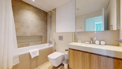 a bathroom with a toilet and a sink and a mirror at Vacationer l High Rise 1 Bedroom l Close to Dubai Mall l Pool Access with Burj Khalifa Views in Dubai