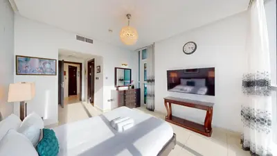 a living room with a couch and a clock on the wall at Vacationer I Lux 3 Bedroom Apartment I Steps from Barasti Beach in Dubai
