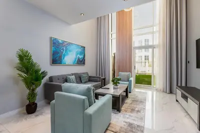 a living room with a couch and a table at Family Friendly, 2BR Townhouse in Rukan Community, Dubai Land - Allsopp & Allsopp in Dubai