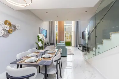 a dining room with a table and chairs at Family Friendly, 2BR Townhouse in Rukan Community, Dubai Land - Allsopp & Allsopp in Dubai