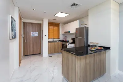 a kitchen with a counter top and a refrigerator at Family Friendly, 2BR Townhouse in Rukan Community, Dubai Land - Allsopp & Allsopp in Dubai