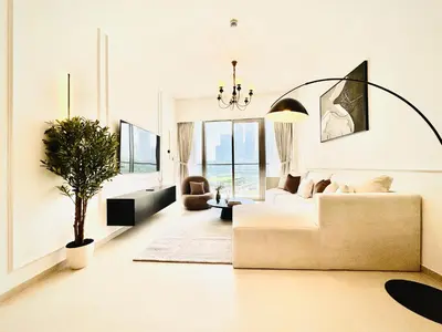 a living room with a couch and a potted plant at Venduras Homes -Grande Tower, Downtown Dubai, Burj Khalifa & Fountain Views in Dubai