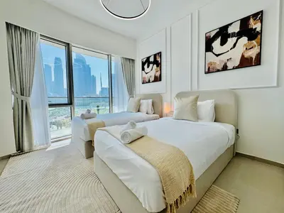 a bedroom with two beds and a large window at Venduras Homes -Grande Tower, Downtown Dubai, Burj Khalifa & Fountain Views in Dubai