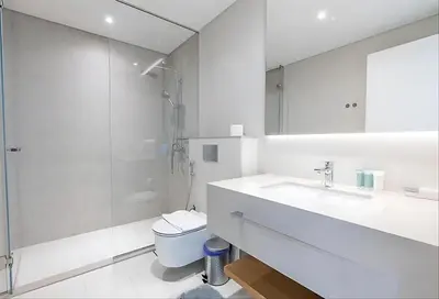 a white bathroom with a toilet and a sink at La Vie JBR Beatiful 1 Bed Seafront in Dubai