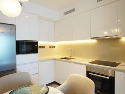a kitchen with white cabinets and a table and chairs at Beach Rental- Grand Creek Harbour in Dubai in Dubai