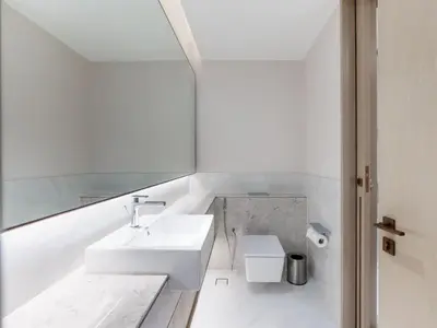 a white bathroom with a sink and a mirror at Beach Rental- Grand Creek Harbour in Dubai in Dubai