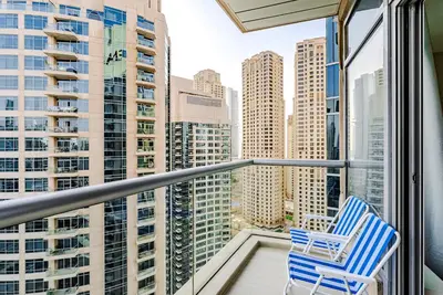 two chairs on a balcony with a view of the city at Breathtaking 1BDR Apartment in Dubai Marina I Bonair I Park Islands in Dubai