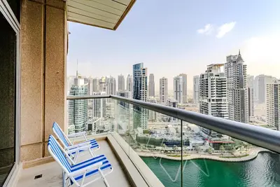 a balcony with two chairs and a view of a city at Breathtaking 1BDR Apartment in Dubai Marina I Bonair I Park Islands in Dubai