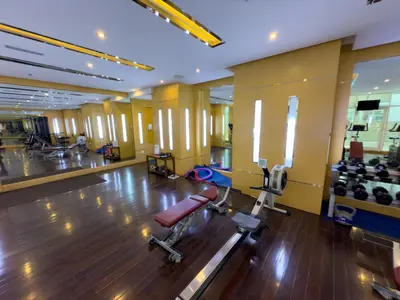 a gym with a bench and a chair in a room at Stilvolle Wohnung im Herzen von Dubai in Dubai