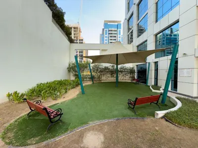 a patio with two benches and a large umbrella at Stilvolle Wohnung im Herzen von Dubai in Dubai