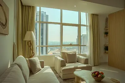 a living room with a couch and a chair and a large window at Stilvolle Wohnung im Herzen von Dubai in Dubai