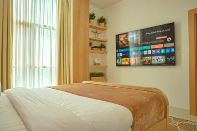 a bedroom with a bed with a tv on the wall at Stilvolle Wohnung im Herzen von Dubai in Dubai