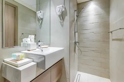 a white bathroom with a sink and a shower at GLOBALSTAY Azizi Riviera 48 in Dubai