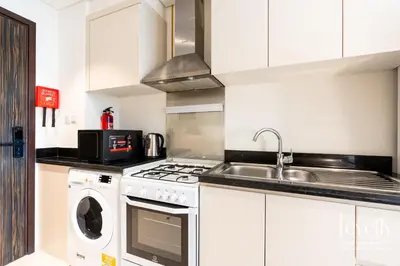 a kitchen with a sink and a stove top oven at Luxury Studio in DAMAC Hills with Premium Amenities in Dubai