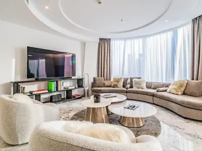 a living room with couches and tables and a tv at Modern & Bright Canal View 2BR Near Dubai Mall by Vibel in Dubai