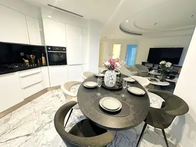 a dining room with a table and chairs in a kitchen at Modern & Bright Canal View 2BR Near Dubai Mall by Vibel in Dubai