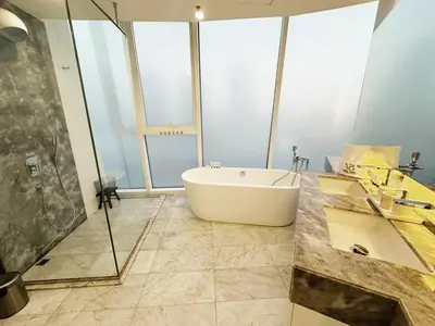 a bathroom with a tub and a glass shower at Modern & Bright Canal View 2BR Near Dubai Mall by Vibel in Dubai