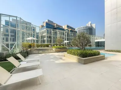 a patio with chairs and tables in a building at Modern & Bright Canal View 2BR Near Dubai Mall by Vibel in Dubai