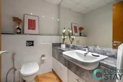 a white bathroom with a sink and a toilet at Cloud 9 - Luxurious 1 Bedroom Apartment in Business Bay in Dubai