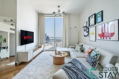 a living room with a couch and a tv at Cloud 9 - Luxurious 1 Bedroom Apartment in Business Bay in Dubai