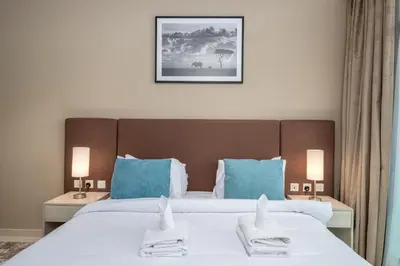 a bedroom with two beds with blue pillows at Charming Studio in Seven Palm with Balcony Rooftop Floor in Dubai