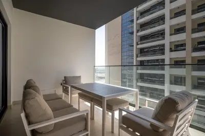 a dining room with a table and chairs and a large window at Chic 1 Bed in Creek Side with Terrace in Dubai