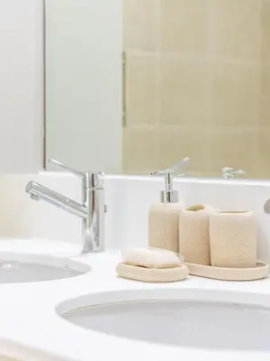 a bathroom sink with three towels on a counter at the Byron Bay condo in Dubai