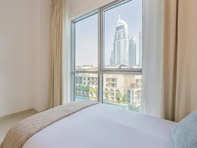 a bedroom with a bed and a large window at the Byron Bay condo in Dubai