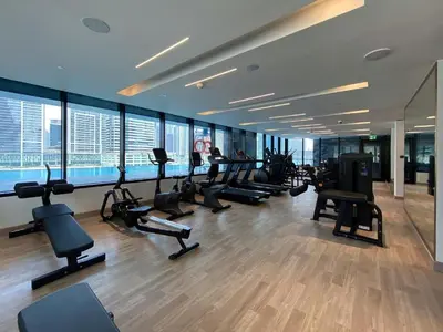 a gym with treadmills and ellipticals in a building at Business Bay Studio Binghatti Canal with Terrace in Dubai