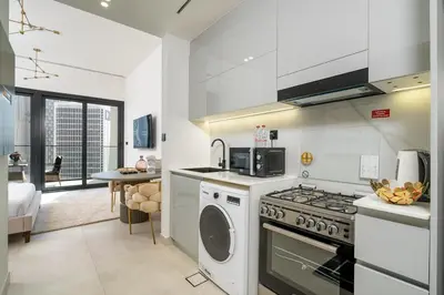 a kitchen with a stove and a washer and dryer at Business Bay Studio Binghatti Canal with Terrace in Dubai