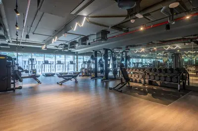 a gym with dumbbells and machines in a room at Downtown Apartment Studio near Burj Khalifa in Dubai