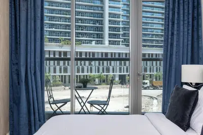 a bedroom with a bed and a large window at Downtown Apartment Studio near Burj Khalifa in Dubai