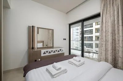a bedroom with a bed with a mirror and a window at Elegant 1 Bed Apartment in Binghatti Creek in Dubai