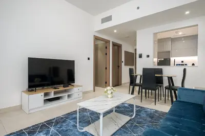 a living room with a blue couch and a tv at Elegant 1 Bed Apartment in Binghatti Creek in Dubai