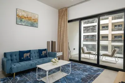 a living room with a blue couch and a table at Elegant 1 Bed Apartment in Binghatti Creek in Dubai