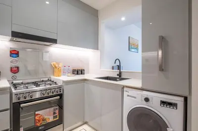 a kitchen with a washing machine and a sink at Elegant 1 Bed Apartment in Binghatti Creek in Dubai
